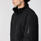 Person wearing a black jacket against a white background