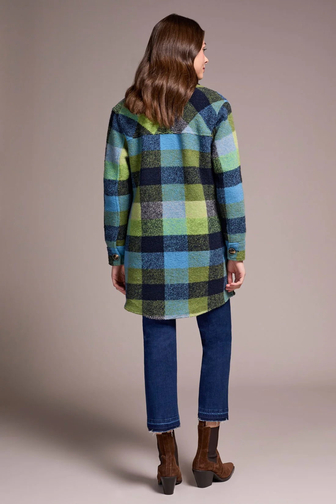 Person wearing a plaid coat with a neutral background