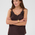 Woman modelling a brown camisole with black pants photographed against a light backdrop.