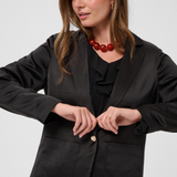 Women modelling a black sateen suit with a black blouse photographed against a light background.