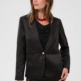 Women modelling a black sateen suit with a black blouse photographed against a light background.