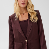 Woman modelling a deep wine coloured sateen blazer with a matching top and pant photographed against a light background.