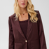 Woman modelling a deep wine coloured sateen blazer with a matching top and pant photographed against a light background.