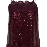 Back of a spaghetti strap sequin top with lace trim photographed against a light background.
