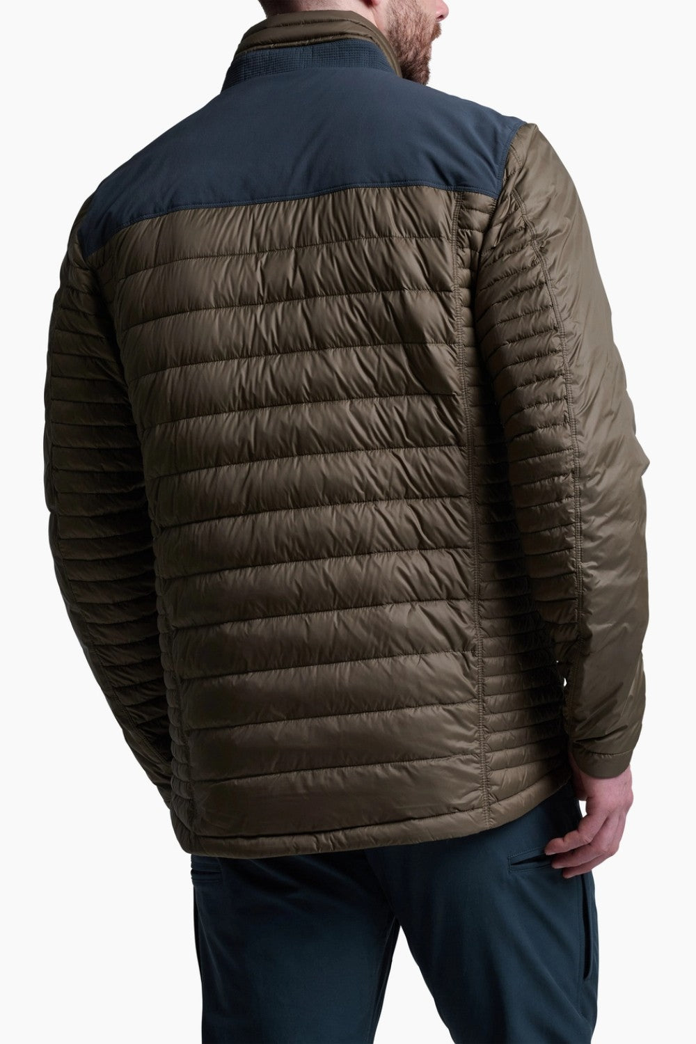 Man wearing a two-tone puffer jacket with a dark blue and brown design on a white background
