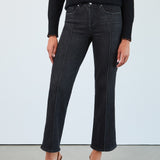 Person wearing black jeans and a black top against a white background