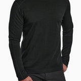 Man wearing a black long-sleeve shirt and black pants on a white background