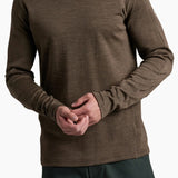 Man wearing a brown long-sleeve shirt and dark pants on a white background