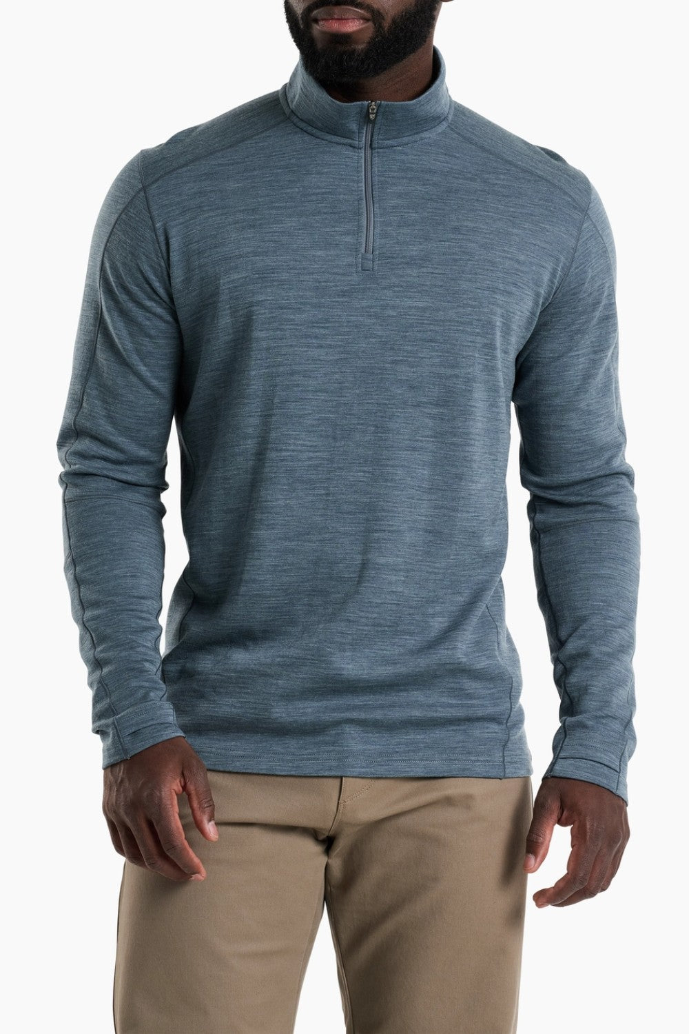 Man wearing a blue long-sleeve shirt with a quarter zip on a white background