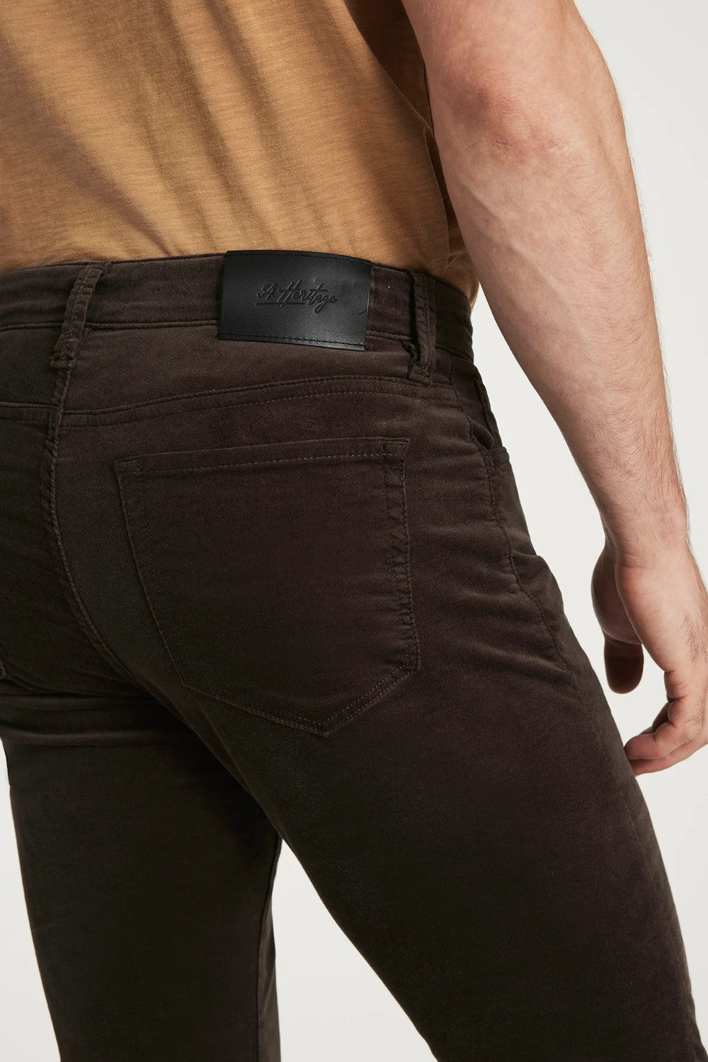 Brown pants worn by a person on a white background