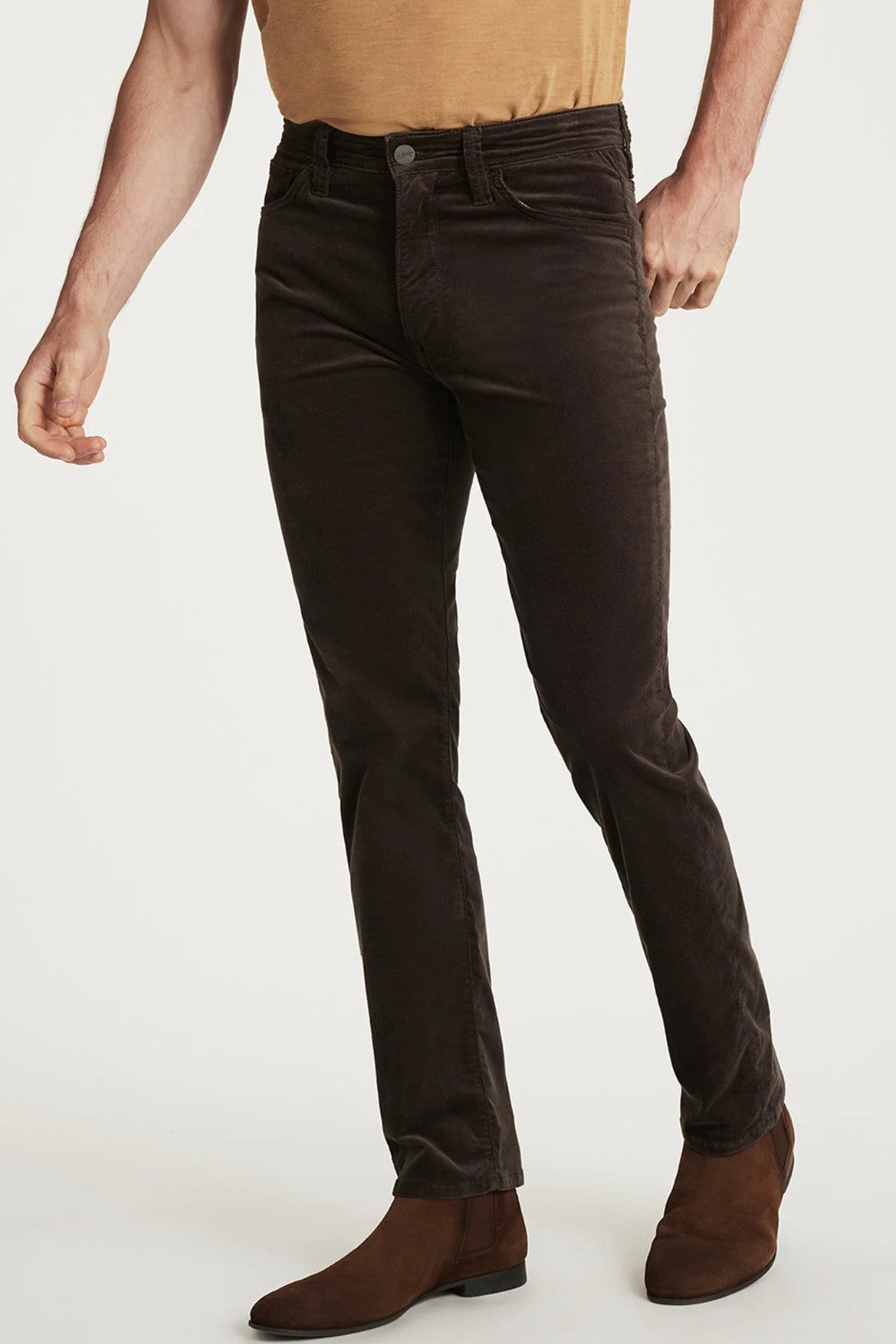 Person wearing brown jeans and brown shoes on a white background