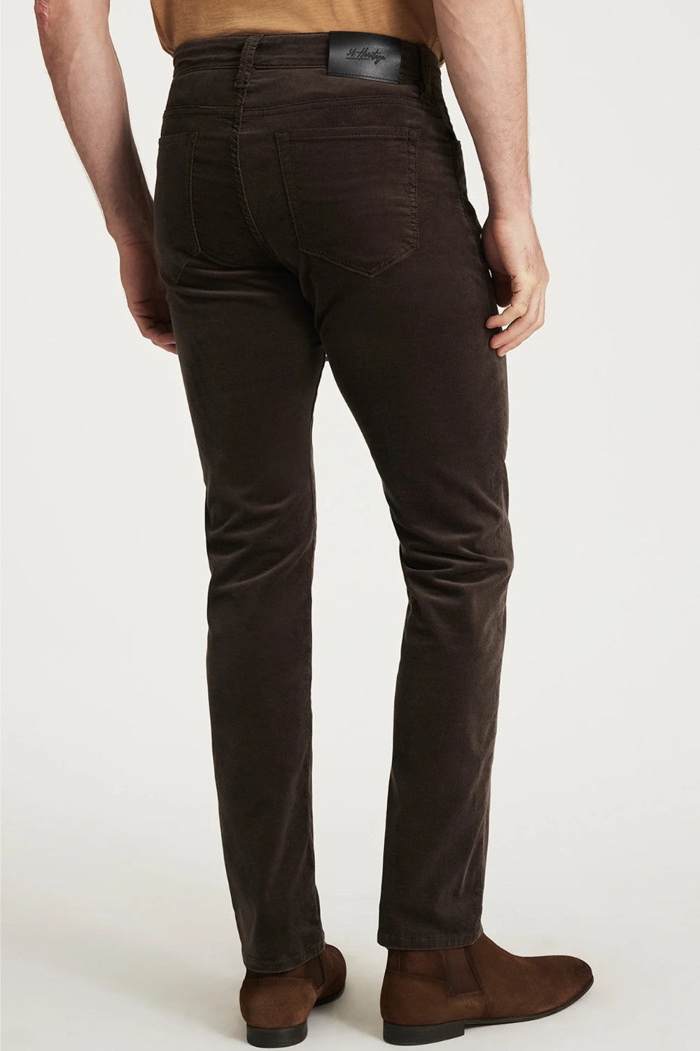 Brown moleskin pants worn by a person on a white background