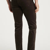 Brown moleskin pants worn by a person on a white background