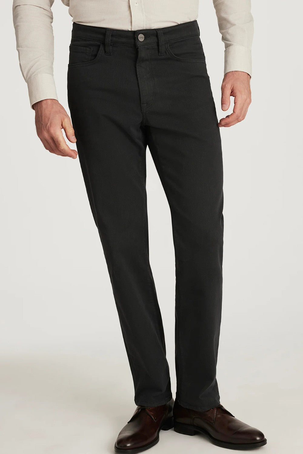 Person wearing charcoal pants and brown shoes on a white background