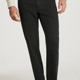 Person wearing charcoal pants and brown shoes on a white background