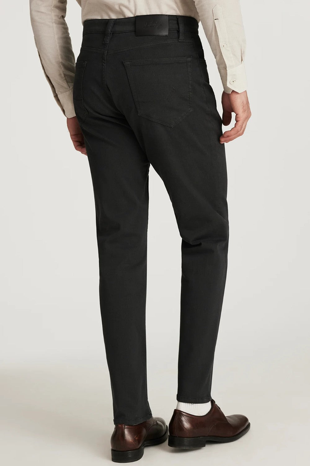 Person wearing charcoal dress pants with a plain background
