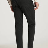 Person wearing charcoal dress pants with a plain background