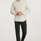 Man wearing a light-colored dress shirt and dark pants on a white background