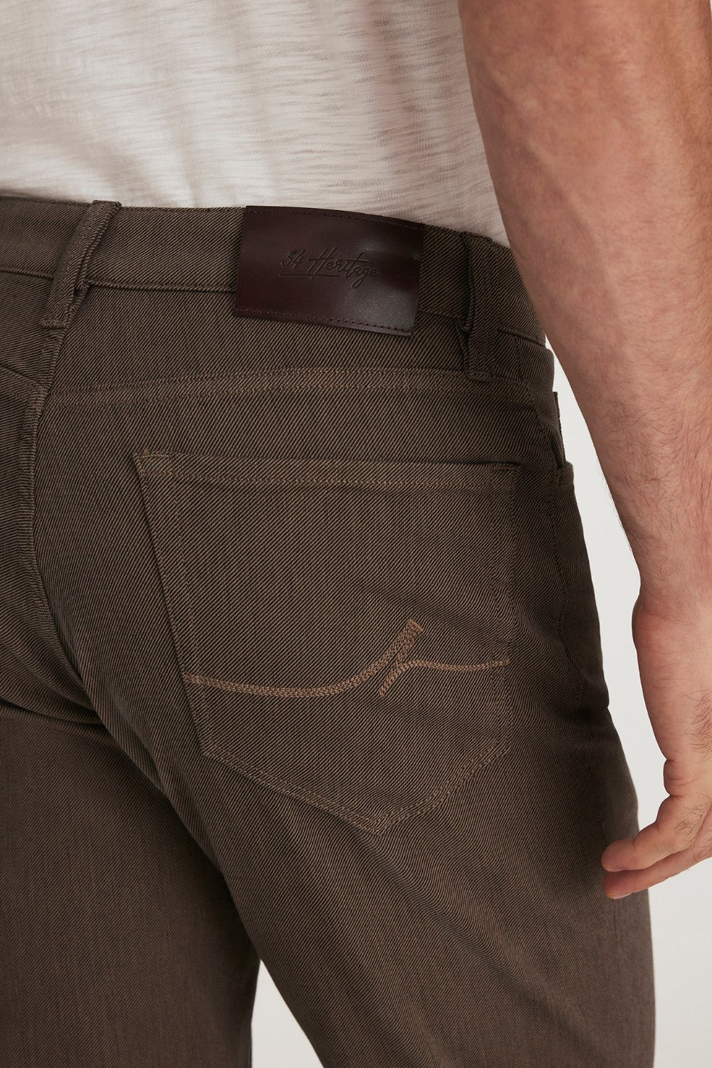Brown pants with a leather patch on a plain background
