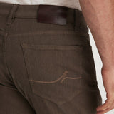 Brown pants with a leather patch on a plain background