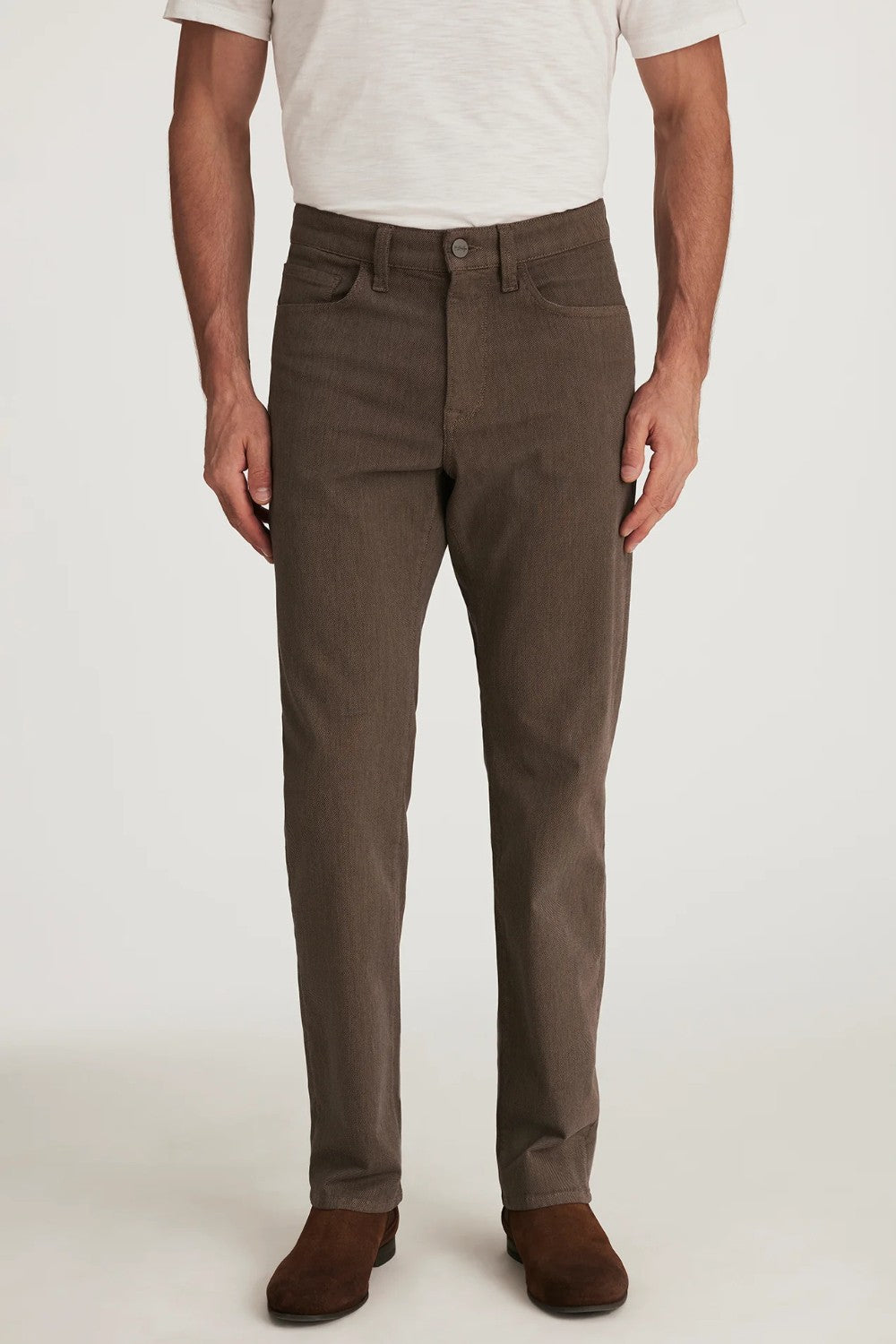 Person wearing brown pants and a white shirt on a plain background