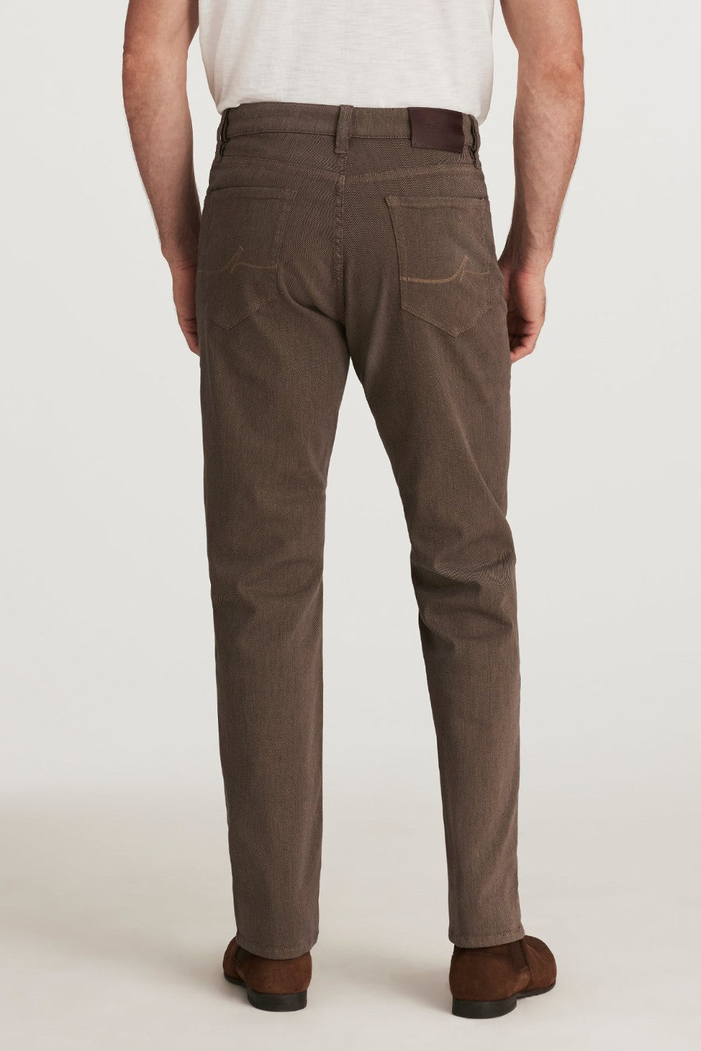 Brown pants worn by a person on a white background