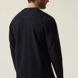 Man wearing a navy long-sleeve shirt on a beige background