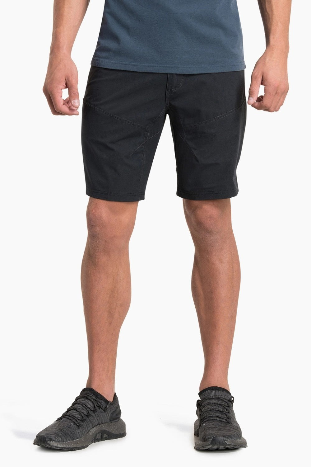 Person wearing black shorts and black shoes on a white background