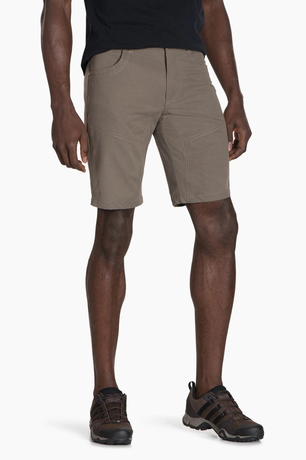 Man wearing beige shorts and brown shoes on a white background