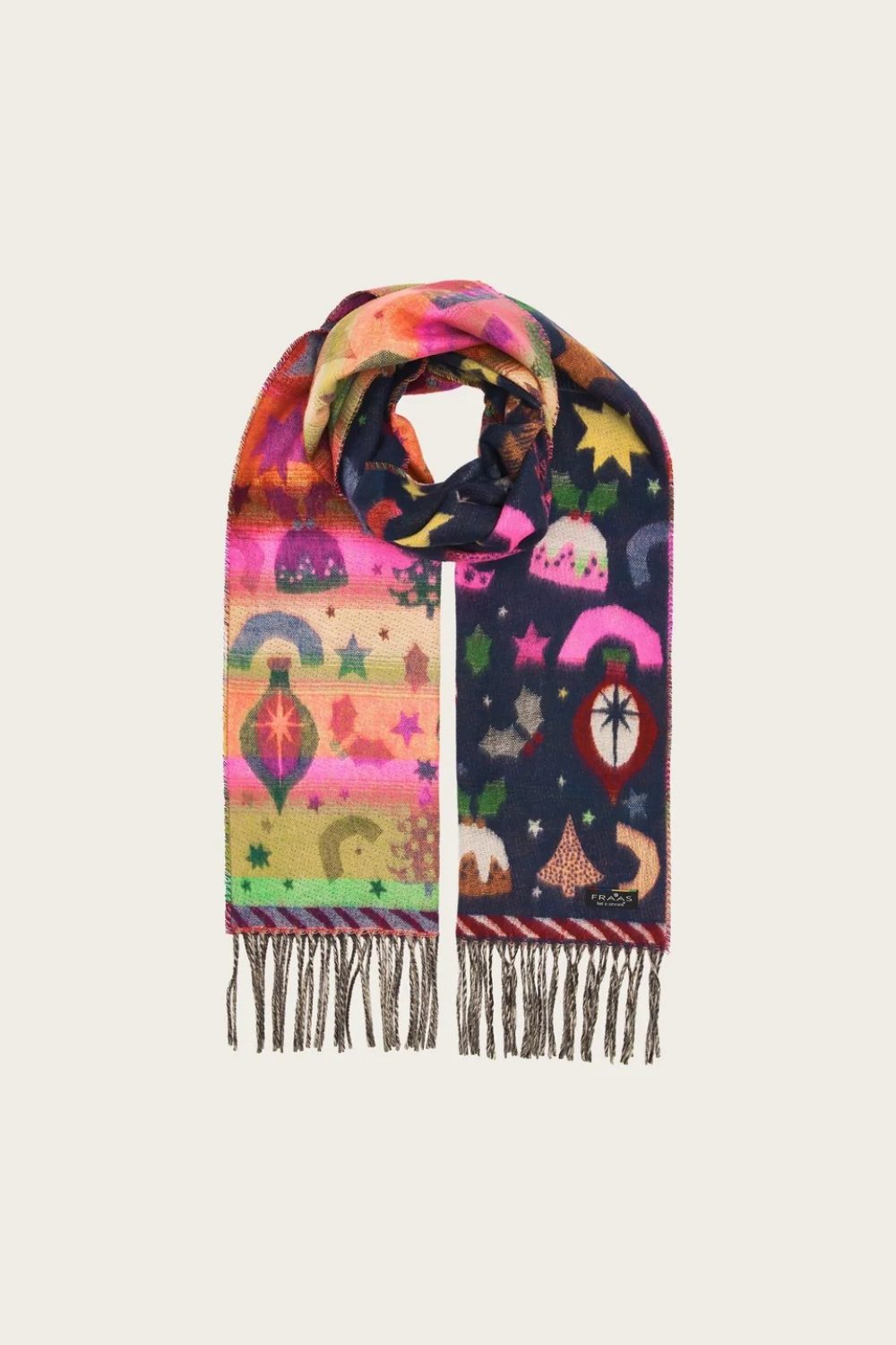 A multicolor patterned scarf with fringe, featuring whimsical celestial and landscape motifs in pink, orange, yellow, green, and navy blue on a light gray background.