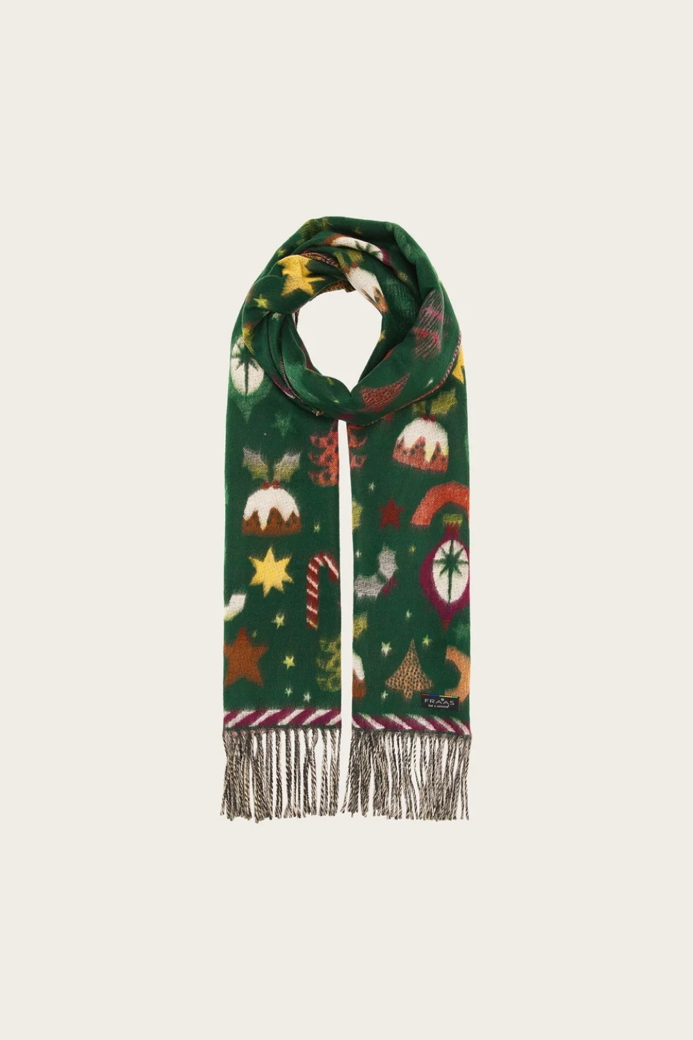 A dark green Christmas-themed scarf with a festive print of candy canes, stars, and mistletoe, finished with fringed ends, shown on a light beige background.
