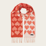 A red and cream heart printed scarf with fringe photographed on a light background.