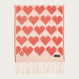 A red and cream heart printed scarf with fringe photographed on a light background.