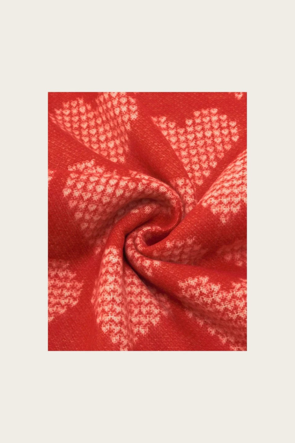 Close up of a red heart printed scarf on a light background.