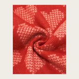 Close up of a red heart printed scarf on a light background.
