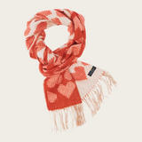 A red and cream heart printed scarf with fringe photographed on a light background.