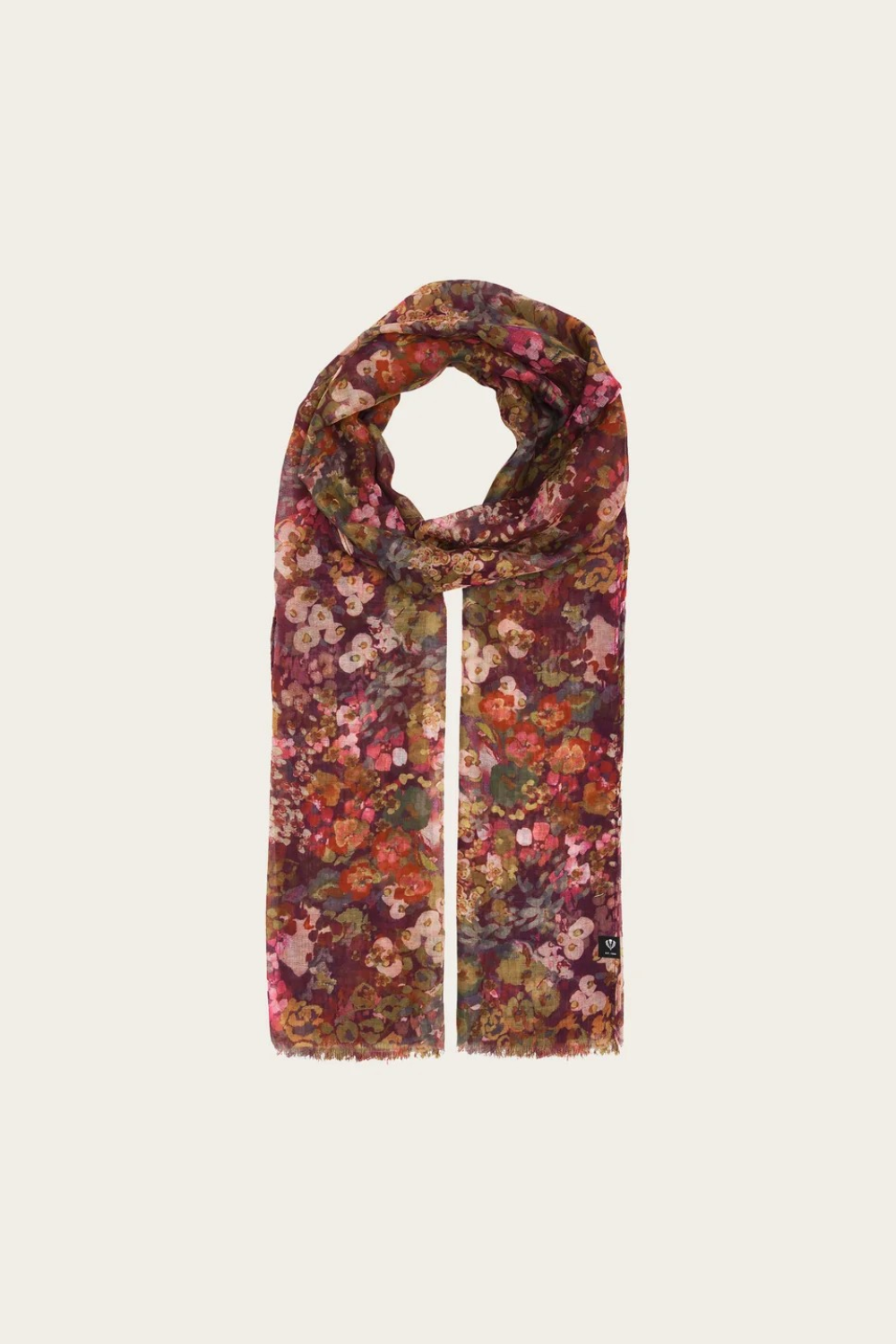Floral print scarf in shades of burgundy, green, orange and pink photographed on a light backdrop.
