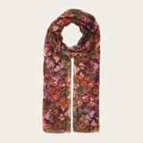Floral print scarf in shades of burgundy, green, orange and pink photographed on a light backdrop.