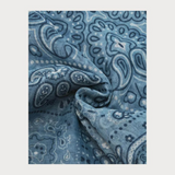 Blue  paisley printed scarf photographed on a light background.