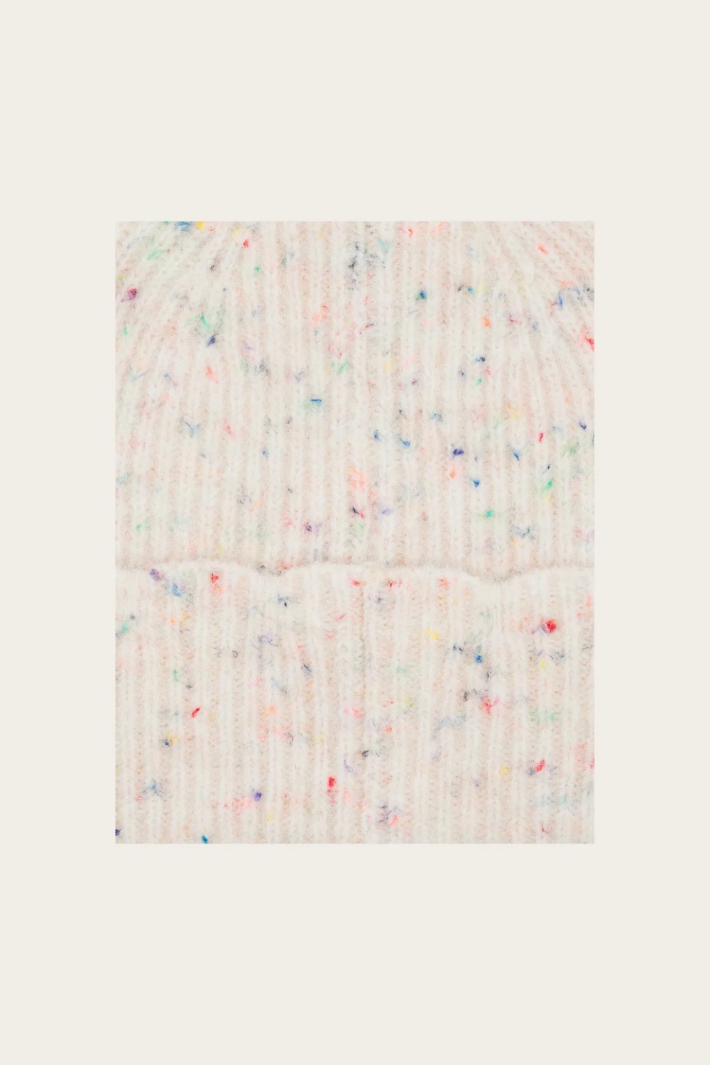 Close up of a cream toque with multi coloured flecks photographed on a light background.