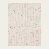 Close up of a cream toque with multi coloured flecks photographed on a light background.