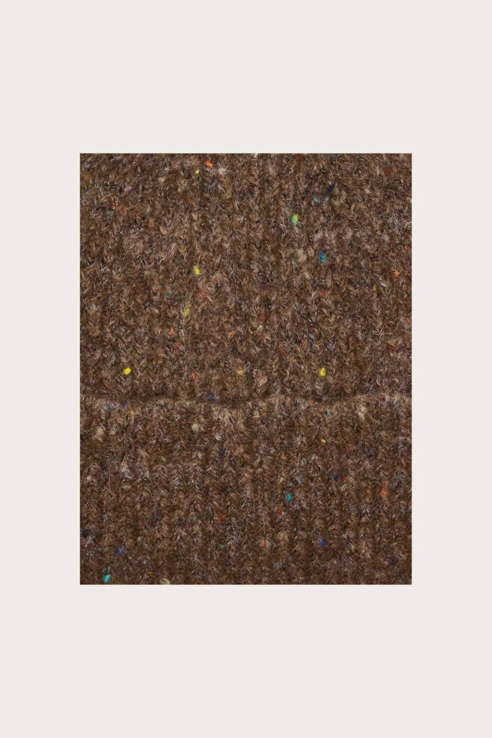 Close up of a brown toque with multi coloured speckles photographed on a light background.