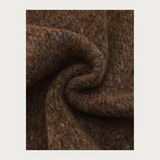 Close up of a brown scarf with multi coloured flecks photographed on a light background.