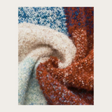 Close up of a multi coloured checkered scarf photographed on a light background.