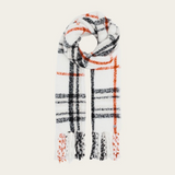 A cream, black and orange plaid scarf with fringe photographed on a light background.