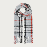 A grey, black and orange plaid scarf with fringe photographed on a light background.
