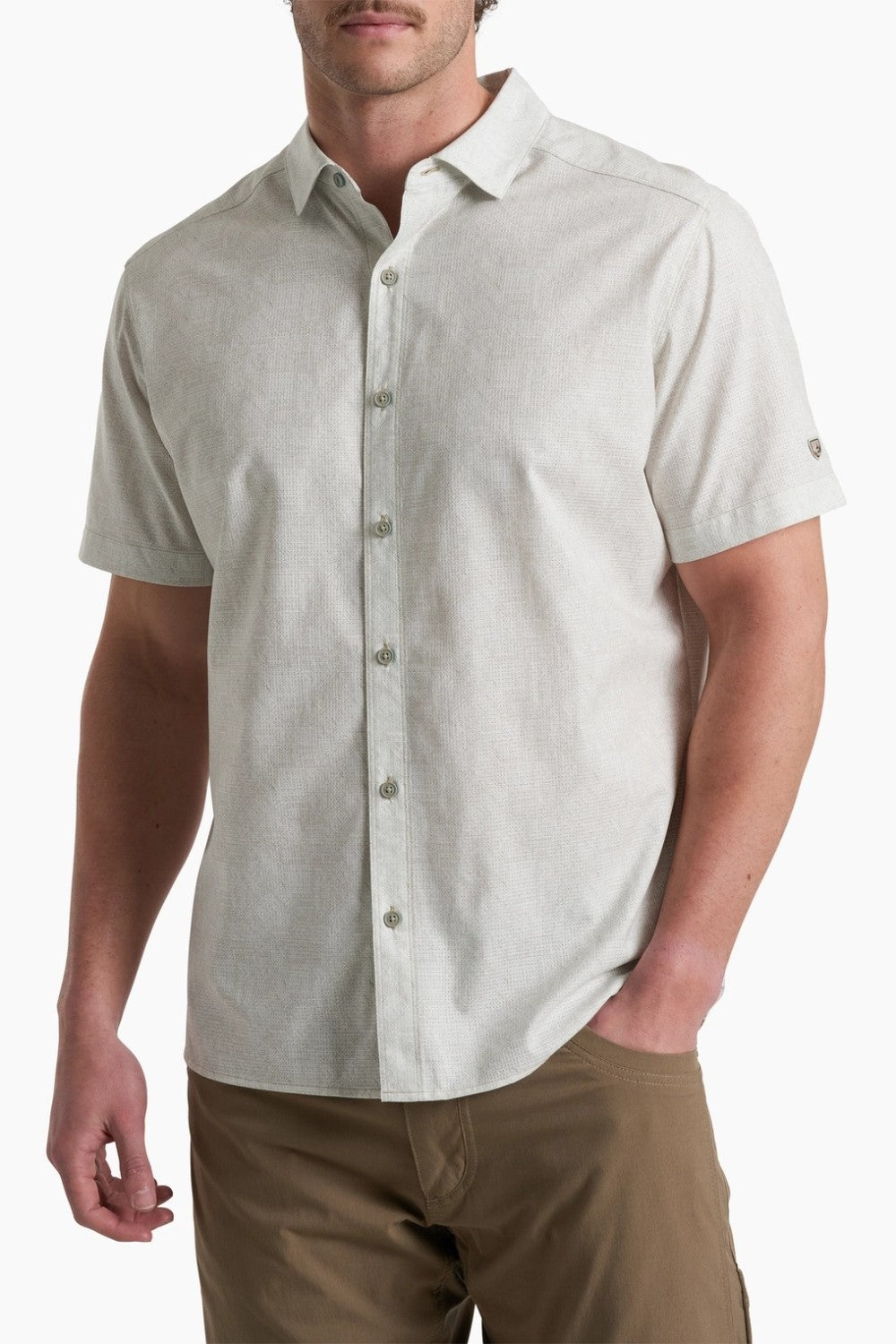 Man wearing a light gray short-sleeve button-up shirt on a white background