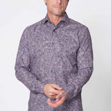 Man wearing a patterned purple shirt against a white background