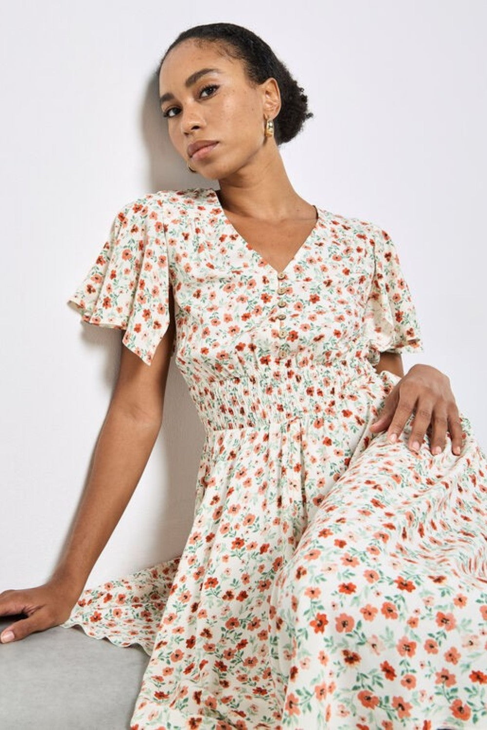 Woman wearing a floral dress against a white background