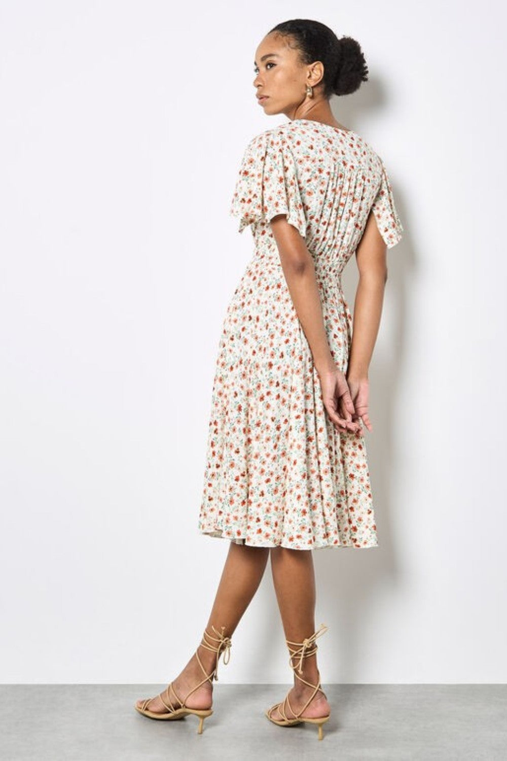 Woman wearing a floral dress with a plain background